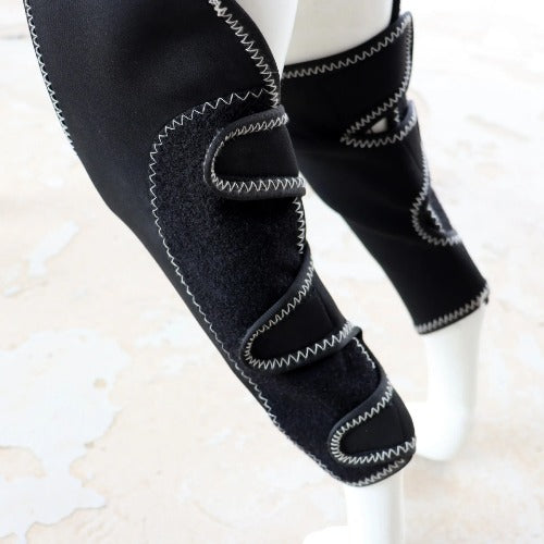 Black knee-high socks with gray stitching on a light background